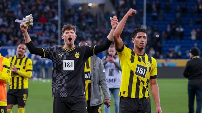Dortmunds Gregor Kobel (l.) und Jude Bellingham jubeln nach dem Spiel gegen Hoffenheim in Richtung Fans.