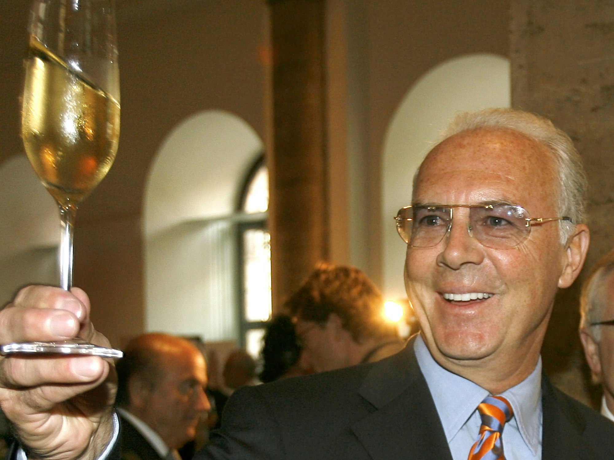 Lachend hebt WM-OK-Chef Franz Beckenbauer während eines Empfanges des DFB in Berlin ein Glas Champagner.