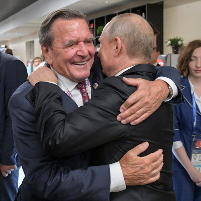 14.06.2018, Russland, Moskau: Gerhard Schröder (SPD, l), ehemaliger Bundeskanzler, umarmt Wladimir Putin, Präsident von Russland, nach dem WM-Eröffnungsspiel Russland gegen Saudi-Arabien.