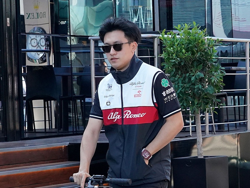 Guanyu Zhou aus China vom Team Alfa Romeo Orlen fährt auf einem Elektroroller im Fahrerlager.