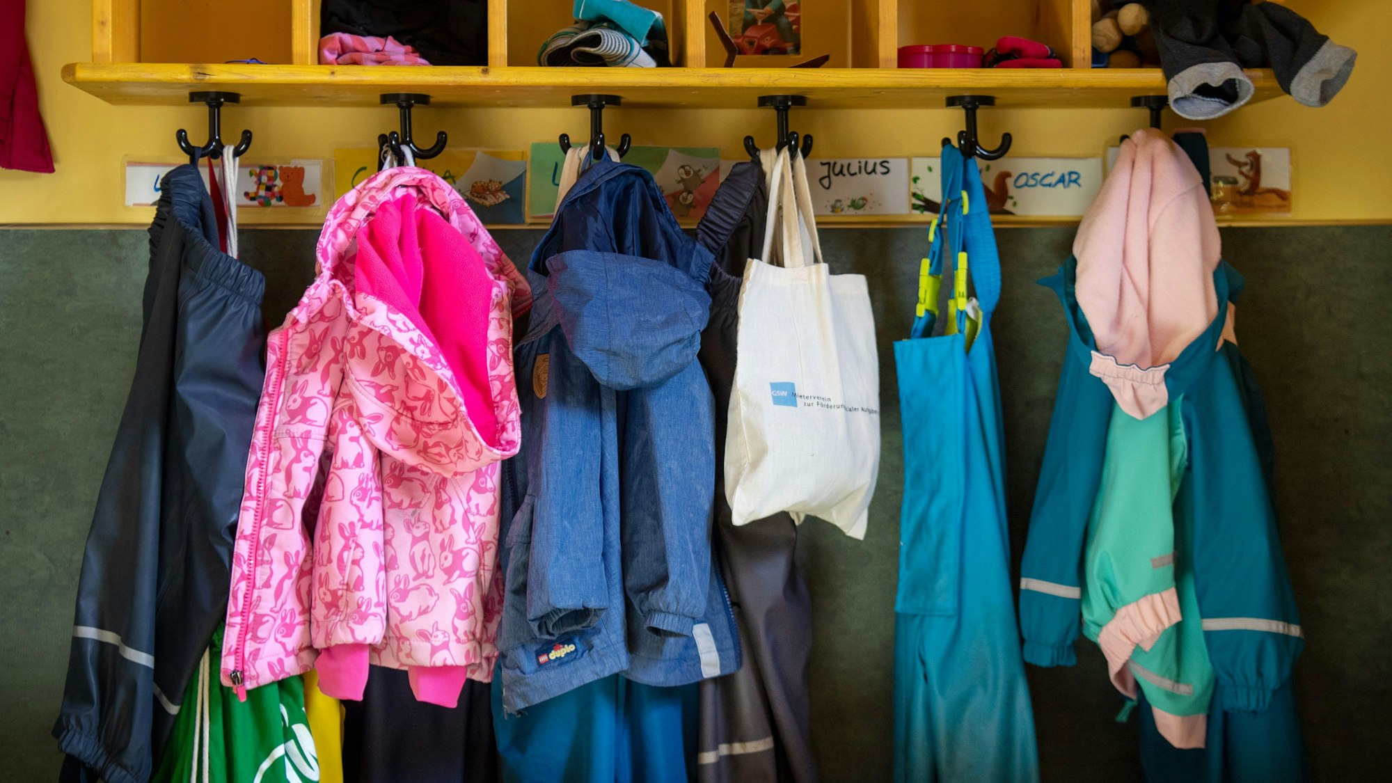 Jacken und Taschen hängen im Eingangsbereich in einem Kindergarten.