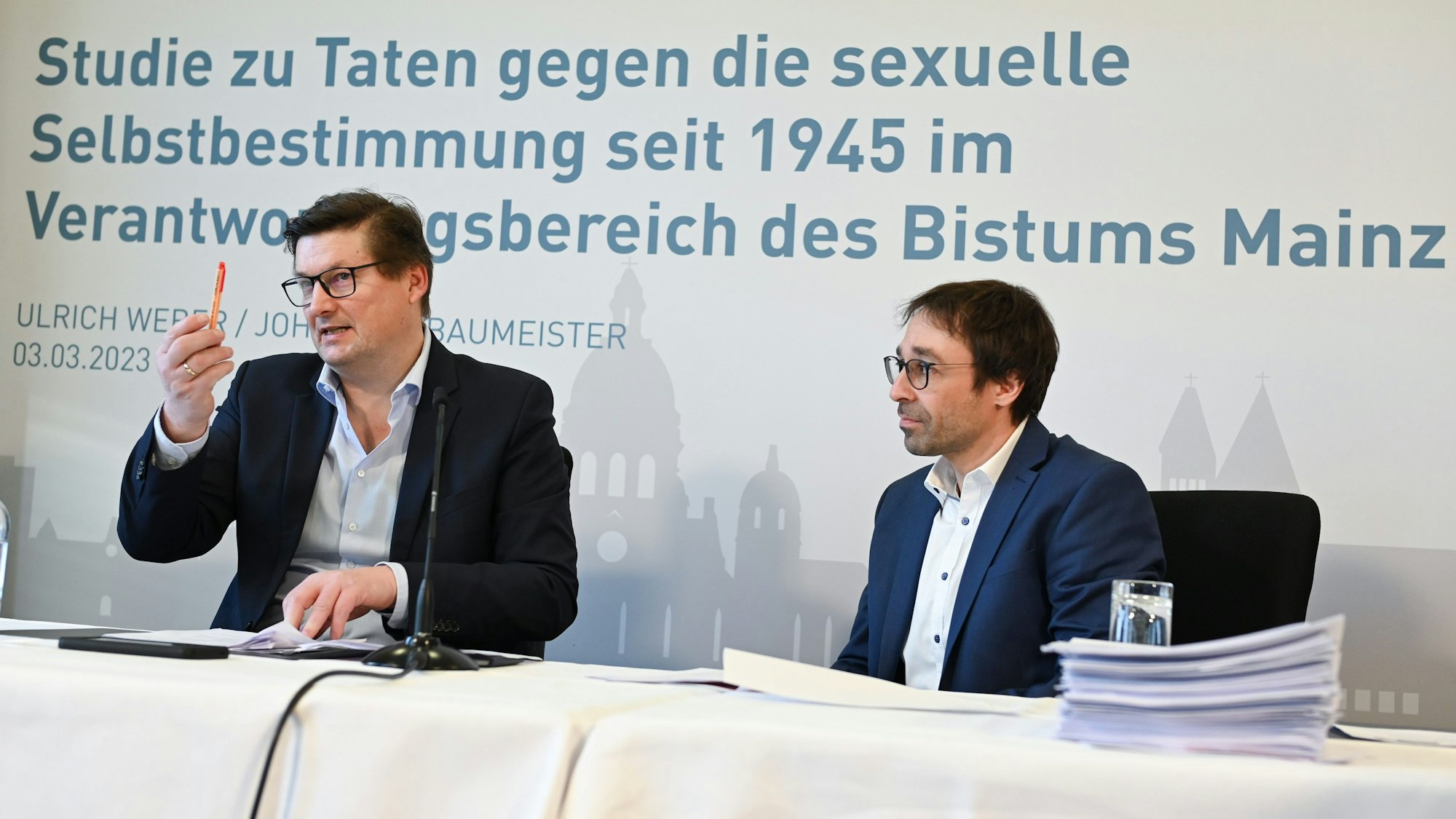 Die Rechtsanwälte Ulrich Weber (l) und Johannes Baumeister haben vor Beginn einer Pressekonferenz zu den Ergebnissen einer Studie zu sexuellem Missbrauch im Bistum Mainz Platz genommen.