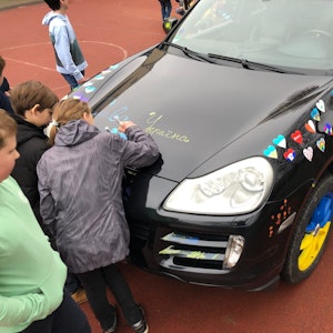 Die Kinder des Carl-von-Ossietzky-Gymnasiums in Bonn verzieren den Friedens-Porsche für die Ukraine.