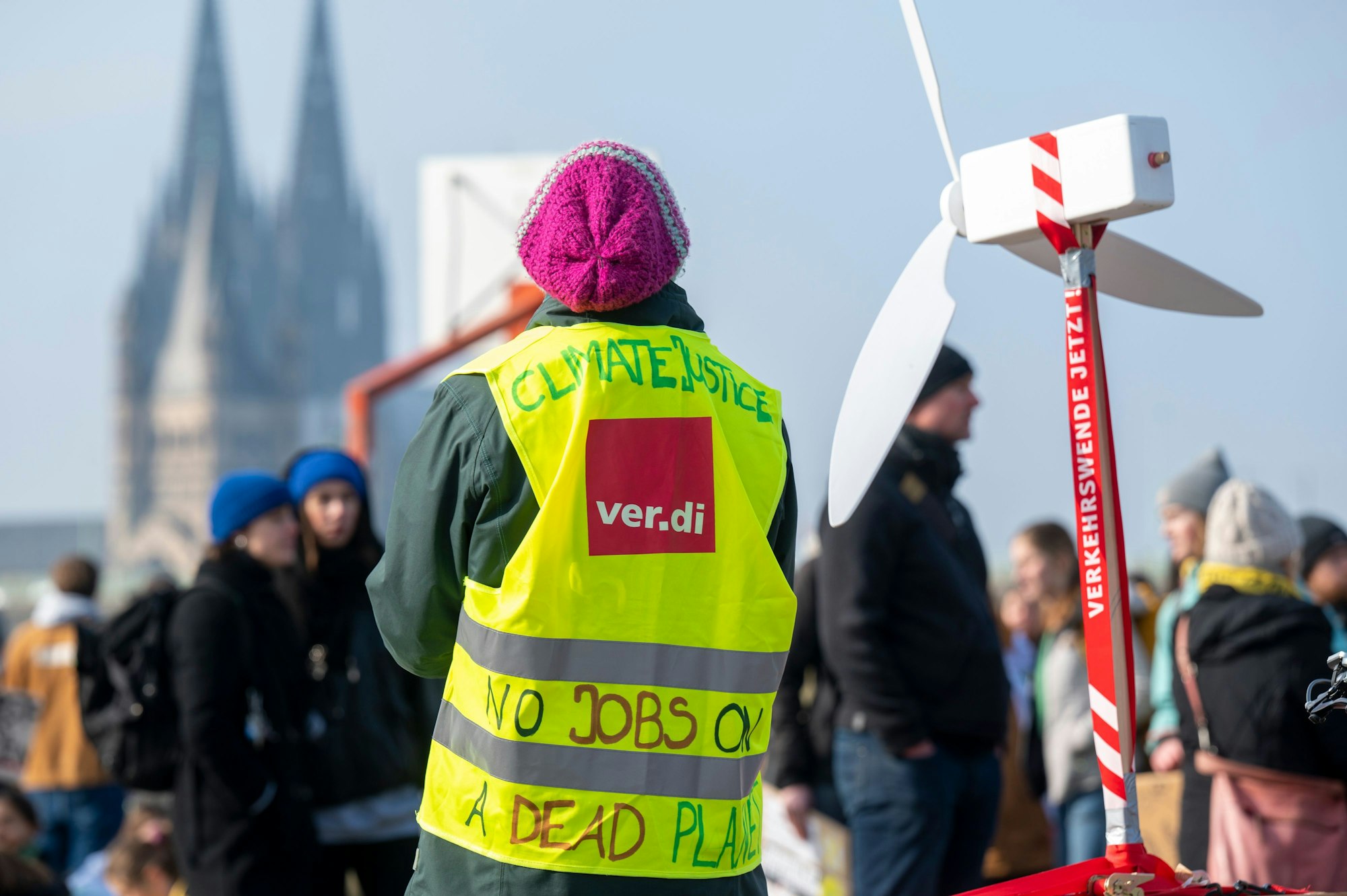 Ein Gewerkschafter demonstriert fürs Klima. Der Kölner Dom ist im Hintergrund zu sehen.