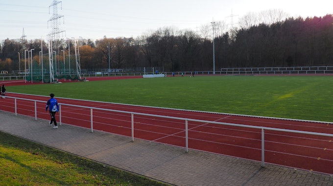 Ein Sportplatz mit roter Laufbahn und Wiese in der Mitte.