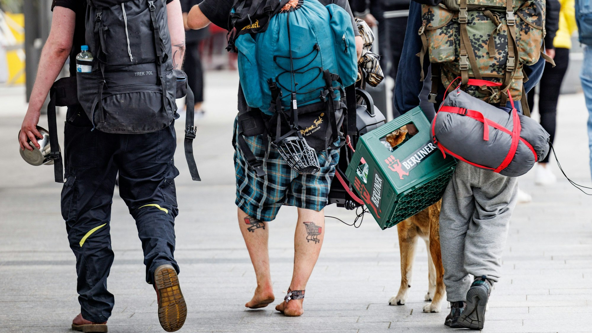 Eine Gruppe Punks schlendert mit Rucksäcken, umgeschnallten Schlafsäcken und einer Kiste Bier in der Hand durch die Fußgängerzone von Westerland auf Sylt.