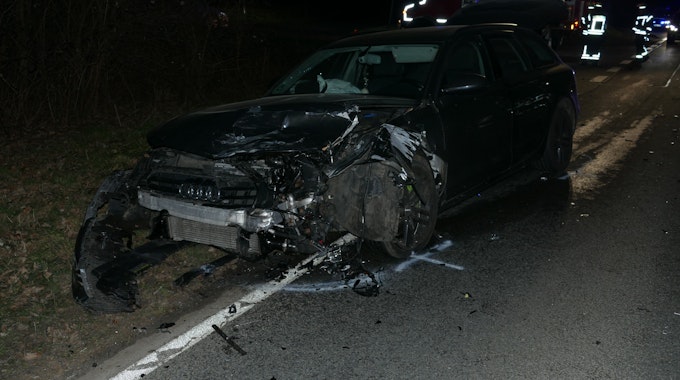 Ein Auto, das vom Unfall an der Vorderseite zerstört ist, steht am Straßenrand