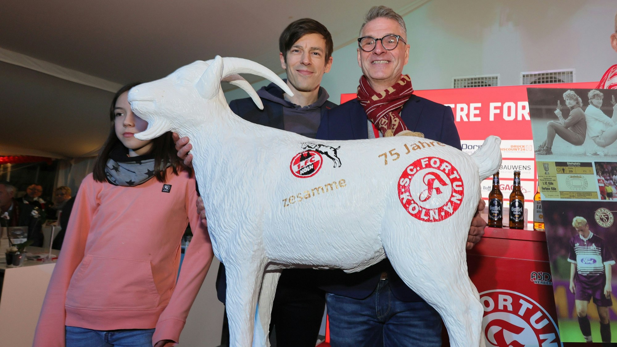 Vize-Präsident Carsten Wettich vom 1. FC Köln übergibt Fortuna Kölns Präsident Hanns-Jörg Westendorf eine Hennes-Figur.