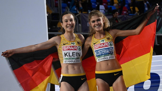 Hanna Klein und Konstanze Klosterhalfen feiern den deutschen Doppelsieg bei der Hallen-EM in Istanbul gemeinsam mit einer Deutschland-Fahne.