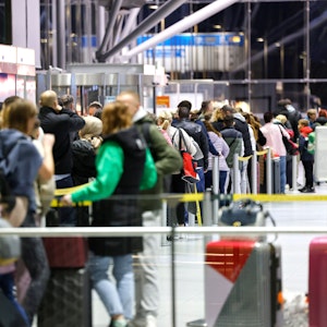 Reisende am Flughafen Köln/Bonn stehen in der Abflughalle an den Schaltern in Schlangen.
