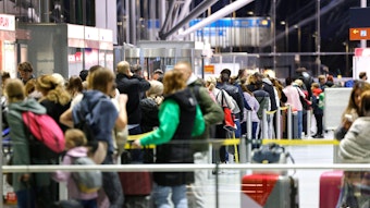 Reisende am Flughafen Köln/Bonn stehen in der Abflughalle an den Schaltern in Schlangen.