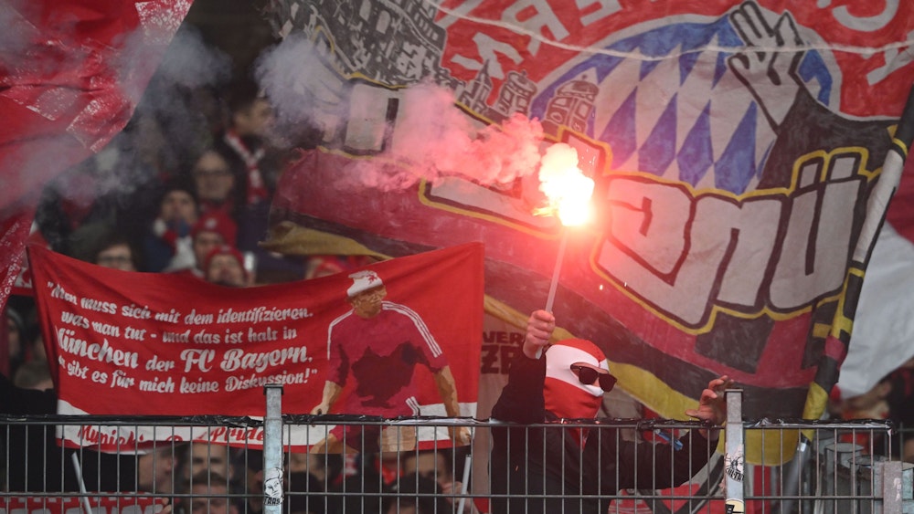 Ein Fan von Bayern München hält eine der vielen Pyro-Fackeln hoch, die der Gäste-Anhang am Samstag beim VfB Stuttgart zündete.