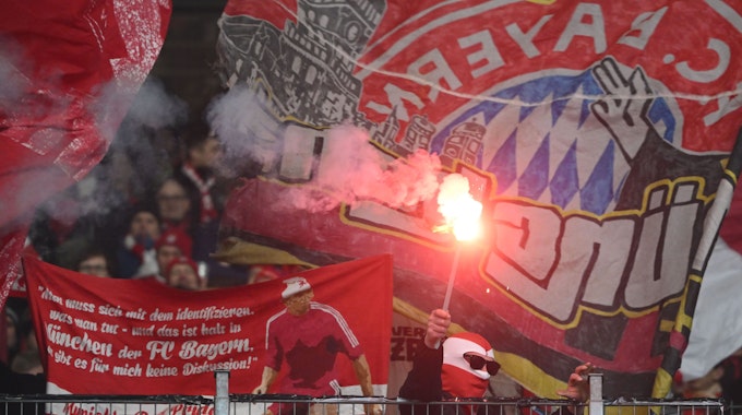 Ein Fan von Bayern München hält eine der vielen Pyro-Fackeln hoch, die der Gäste-Anhang am Samstag beim VfB Stuttgart zündete.