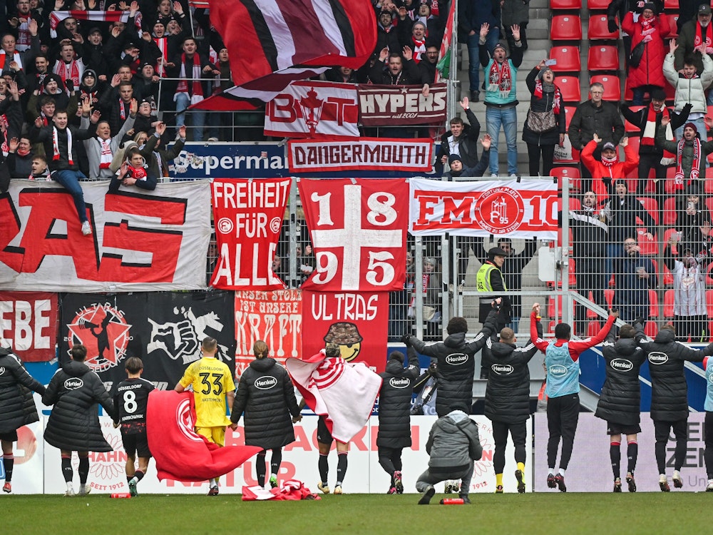 Die Mannschaft von Düsseldorf jubelt nach dem 1:0 in Regensburg mit den Fans.