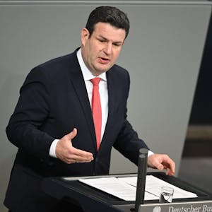 Hubertus Heil (SPD), Bundesminister für Arbeit und Soziales, spricht am Rednerpult im Plenum des Deutschen Bundestags. Er trägt einen schwarzen Anzug und rote Krawatte.