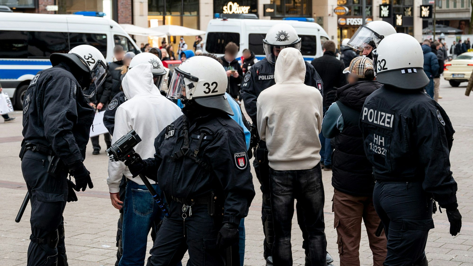 Polizisten kontrollieren in der Einkaufsstraße Mönkebergstraße in Hamburg mehrere Jugendliche.