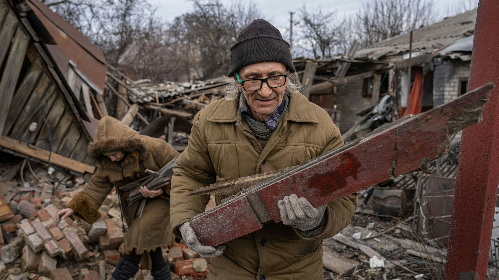 Hennadiy Mazepa und seine Frau Natalia Ishkova sammeln Holz aus einem Haus, das von russischen Truppen in Tschassiw Jar zerstört wurde.