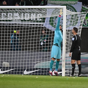 Frankfurt-Keeper Kevin Trapp misst beim Spiel in Wolfsburg mit seinem Körper nach, ob das Tor zu groß ist.