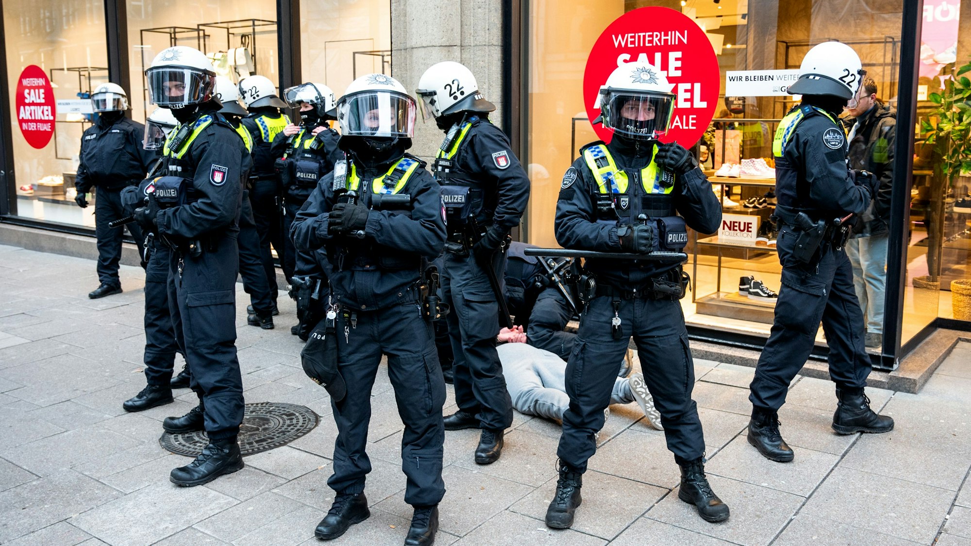 Das Foto vom 4. März 2023 zeigt mehrere Polizistinnen und Polizisten im Einsatz. Sie bilden einen Kreis um einen Jugendlichen, der von einem Beamten am Boden festgehalten wird.