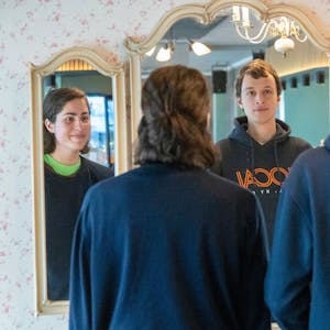 Franka Höfler und Mattes Wiegmann stehen vor einem Spiegel. Ihre Gesichter sind nur im Spiegel zu sehen.