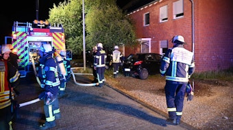 Auf dem Foto ist der Löscheinsatz der Feuerwehr zu sehen, nachdem im Treppenhaus eines Mehrfamilienhauses in Bergheim ein Feuer ausgebrochen worden war.