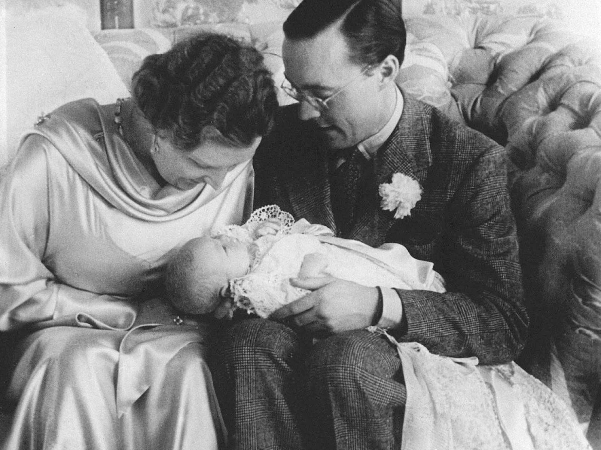 Königin Juliana und Prinz Bernhard halten ihre erste Tochter Prinzessin Beatrix in einem Taufkleid.