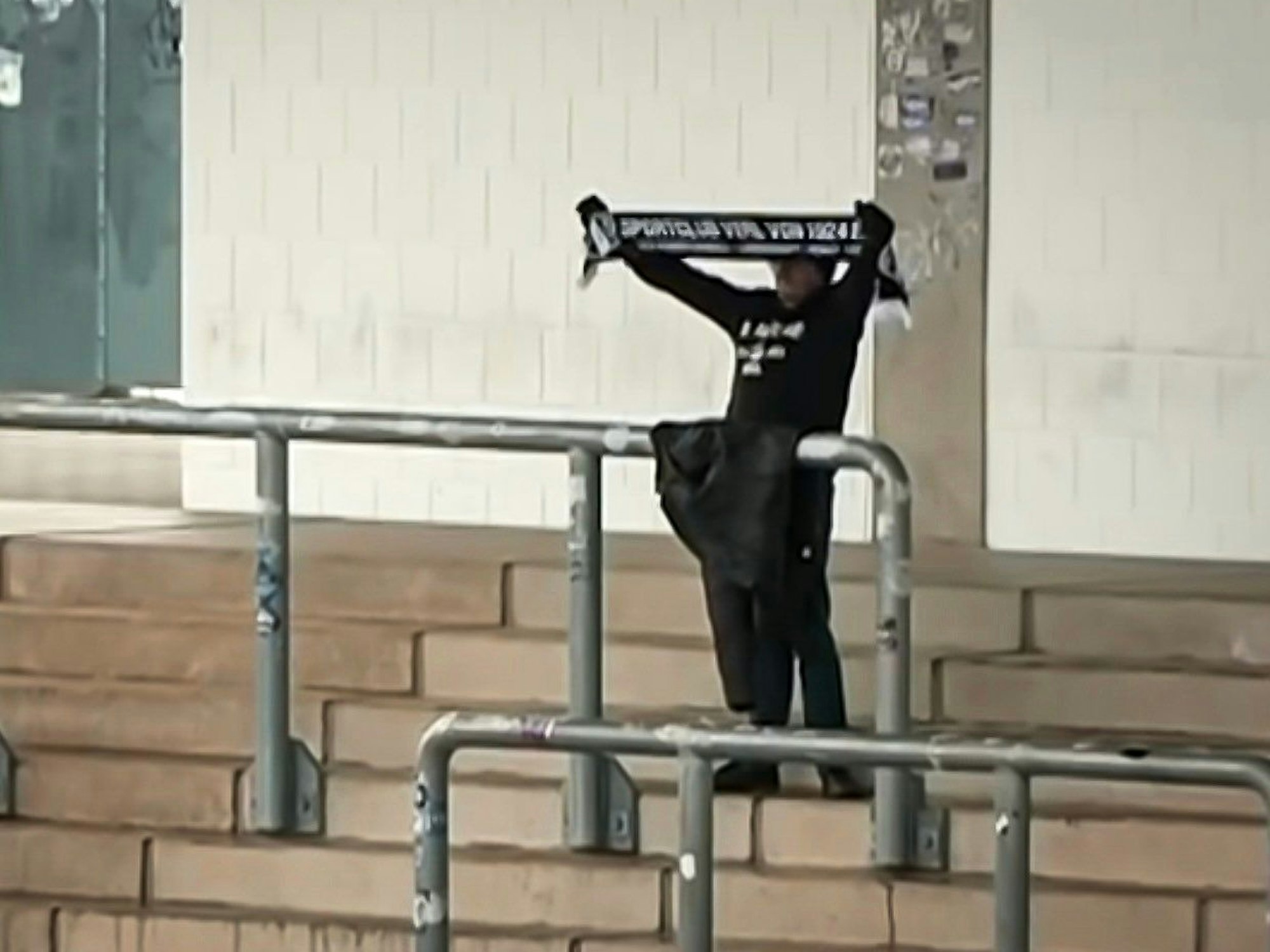Ein Fan des SC Verl hält seinen Schal hoch.