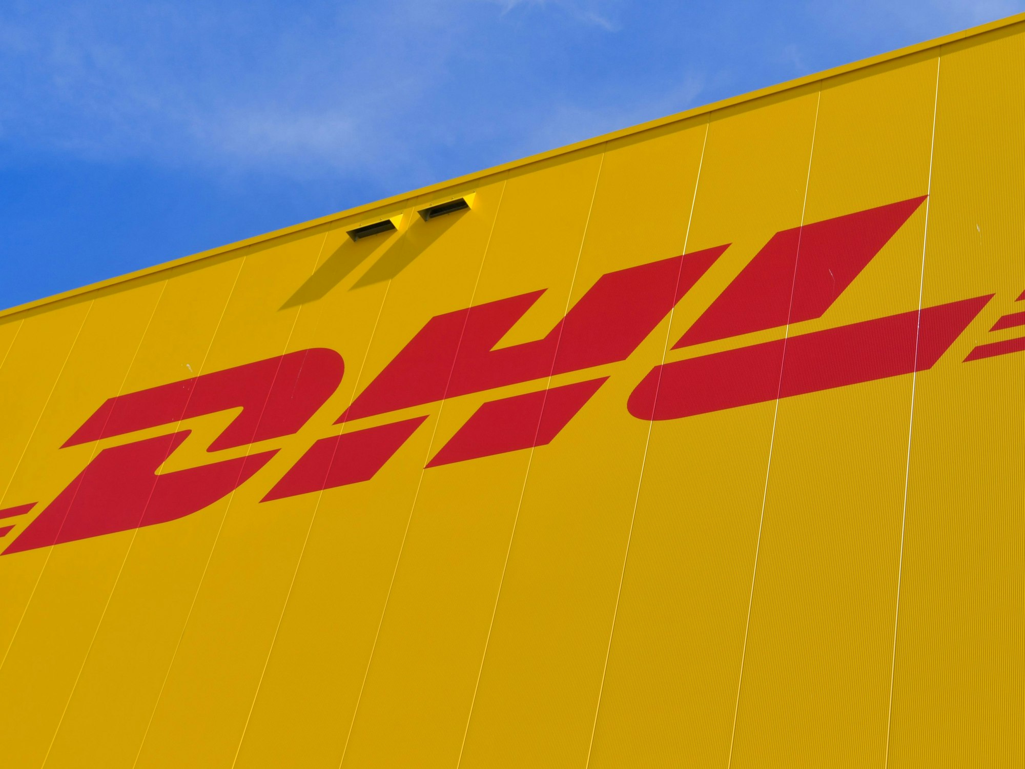 Das Logo des Paketdienstes DHL der Deutschen Post auf der Fassade eines Paketzentrums im Juni 2020 in Ludwigsfelde.