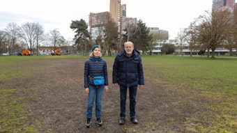 Anwohnerin Aleke Schücking und Helmut Röscheisen vom BUND stehen auf einer ramponierten Wiese im Grüngürtel