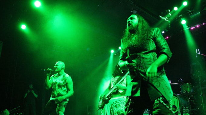 Auf der in grünes Licht getauchten Bühne stehen die beiden Sänger indischen Metal-Band Bloodywood.