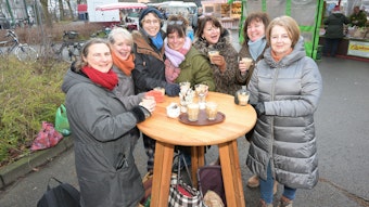 Sieben Frauen stehen mit Kaffee um einen Stehtisch auf dem Markt in Bergisch Gladbach-Refrath.