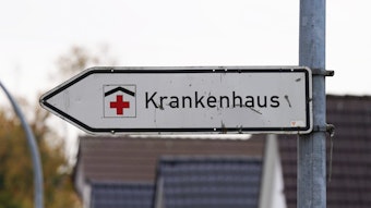 Ein Hinweisschild mit der Aufschrift „Krankenhaus“ weist an einer Straße den Weg zu einer Klinik.