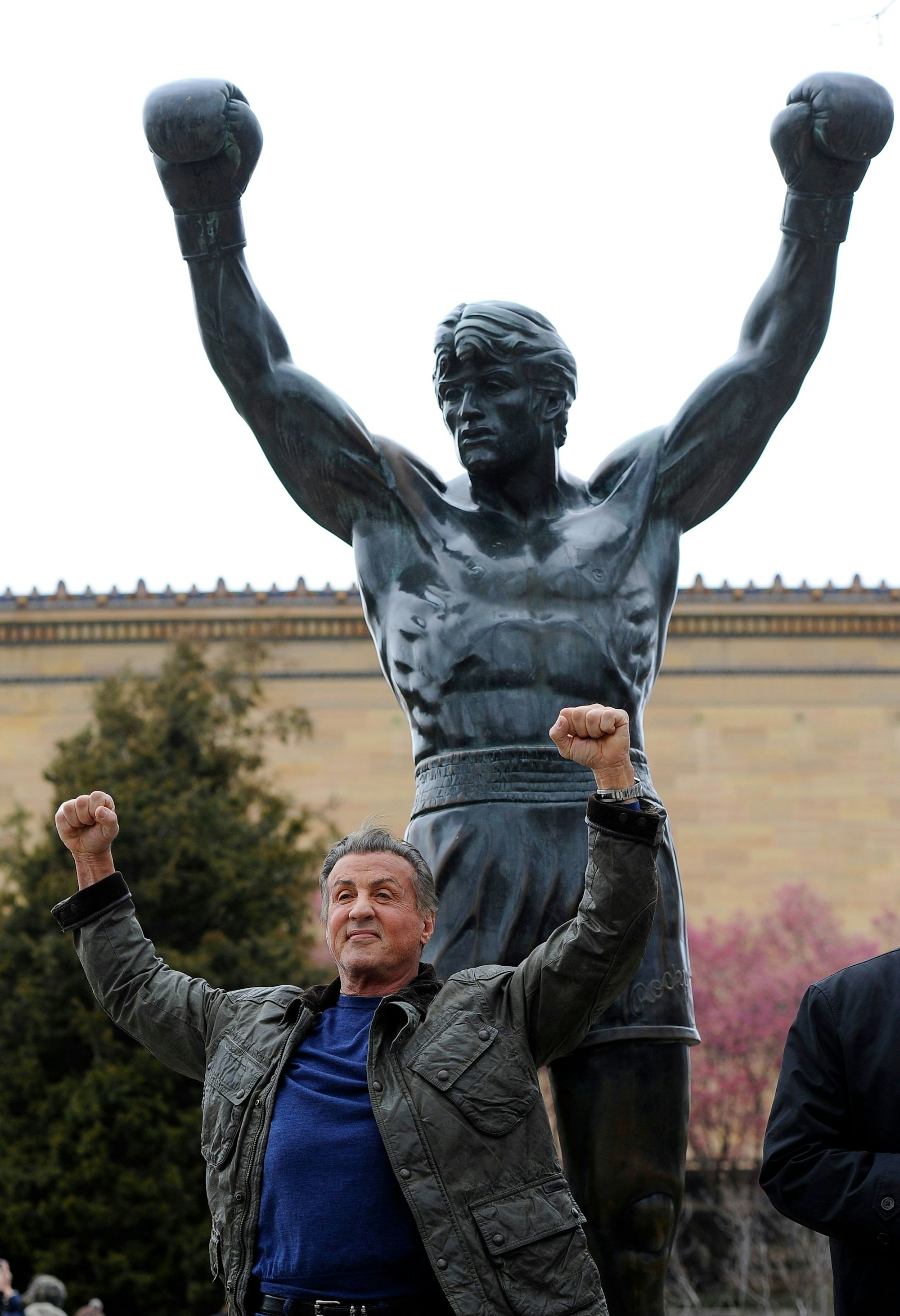 Schauspieler Sylvester Stallone steht vor der Statue des fiktiven Boxers Rocky, die vor dem Philadelphia Art Museum zu sehen ist.