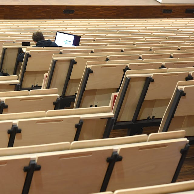 Ein Student sitzt in einem ansonsten leeren Vorlesungssaal.&nbsp;