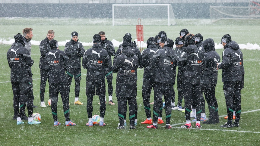 Die Mannschaft von Borussia Mönchengladbach bildet vor dem Training am 20. Januar 2023 bei dichtem Schneefall einen Kreis.