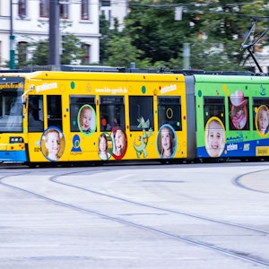 Das Symbolfoto aus dem Jahr 2020 zeigt eine bunte Straßenbahn und einen roten Bus.