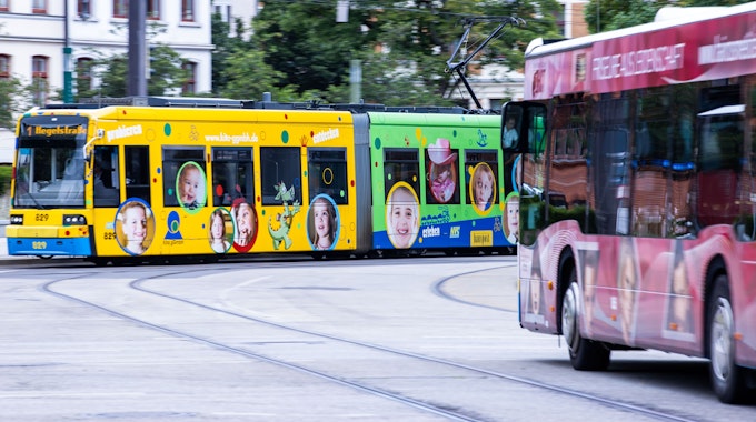 Das Symbolfoto aus dem Jahr 2020 zeigt eine bunte Straßenbahn und einen roten Bus.