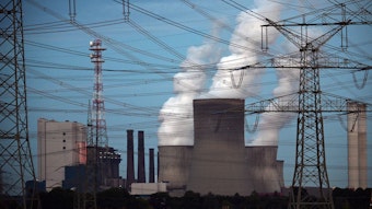 Niederaußem: Dampf kommt aus den Kühltürmen des Braunkohlekraftwerkes Niederaußem. Ringsum sind Strommasten und -kabel zu sehen.