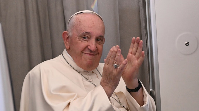 Papst Franziskus klatscht im Februar 2023 während einer Pressekonferenz an Bord eines Flugzeugs, das nach Rom fliegt.&nbsp;