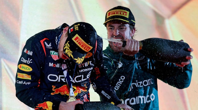 Sieger Max Verstappen (links) und Fernando Alonso feiern am 5. März auf dem Treppchen des Großen Preises von Bahrain den Formel-1-Auftakt in die Saison 2023.