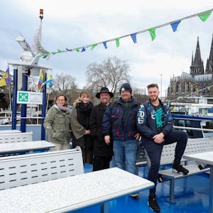 Das Team von Köln-Tourist auf dem Deck eines Schiffes, im Hintergrund der Dom und der Musical Dome