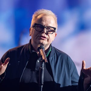 Der deutsche Sänger Herbert Grönemeyer steht auf einer Bühne.