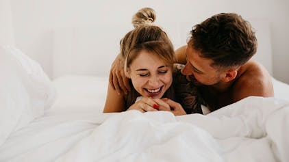 Mann und Frau glücklich im Bett