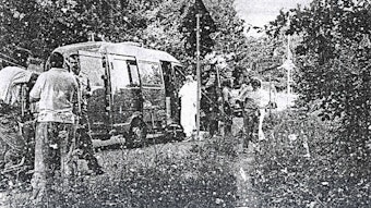 Spurensuche am Tatort im Juli 1992: Ermittler in weißen Overalls stehen in einem Waldstück in Refrath.