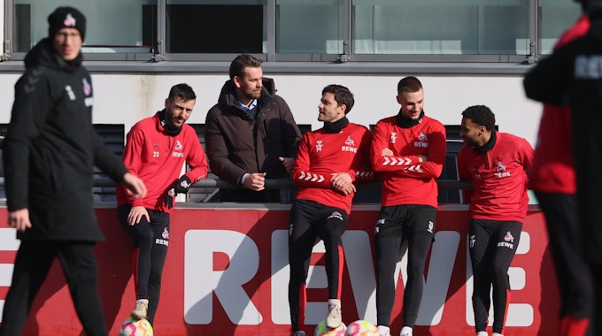 Sargis Adayan unterhält sich beim Training des 1. FC Köln an der Bande mit Thomas Kessler, Jonas Hector, Tim Lemperle und Linton Maina.