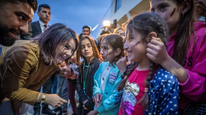 Annalena Baerbock lächelt einem irakischen Kind entgegen