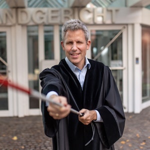Der blinde Jurist Ulrich Badde steht mit einem Blindenstock vor dem Landgericht in Münster.