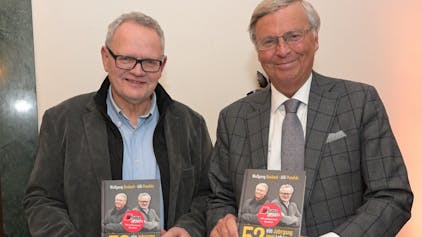 Wolfgang Bosbach, CDU Urgestein, und Ulli Potofski, Sportjournalist, stehen nebeneinander und präsentieren ihr gemeinsames Buch.