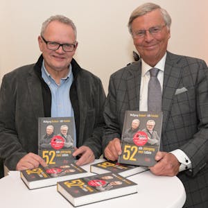 Wolfgang Bosbach, CDU Urgestein, und Ulli Potofski, Sportjournalist, stehen nebeneinander und präsentieren ihr gemeinsames Buch.