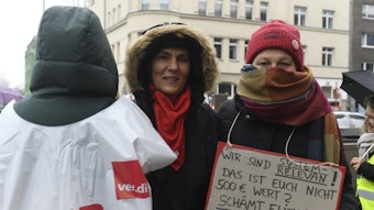 Mitarbeiterinnen des Hilfetelefons demonstrieren in Köln für höhere Löhne im Sozialsektor. Einige Beteiligte wollten ihre Gesichter verdecken.